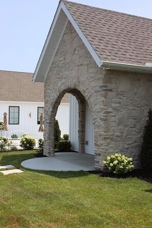 A house with a stone facade, a pitched roof, and a front porch with a stone archway. - Studio in Sugarcreek Steps away from Spa and Café (Sugarcreek)