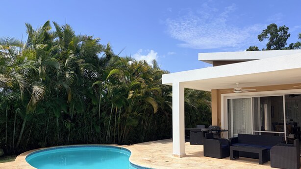 A swimming pool with a curved edge, surrounded by a patio area with outdoor furniture. - Breezy, Beautiful 2 Bedroom Caribbean Villa! (Sosúa)