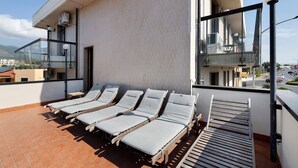 Una terrazza sul tetto con lettini e vista sulla città.