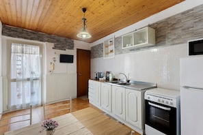 A kitchen with white cabinets, a stove, and a microwave.