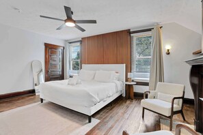 A bedroom with a bed, a chair, a ceiling fan, and a window with blinds. - 1918 Charm Meets Modern  OSU-Close Gem (Columbus)
