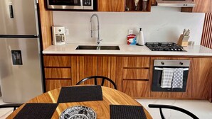Eine moderne Küche mit Holzschränken, Edelstahlgeräten und einem Essbereich mit einem Tisch mit Muster.