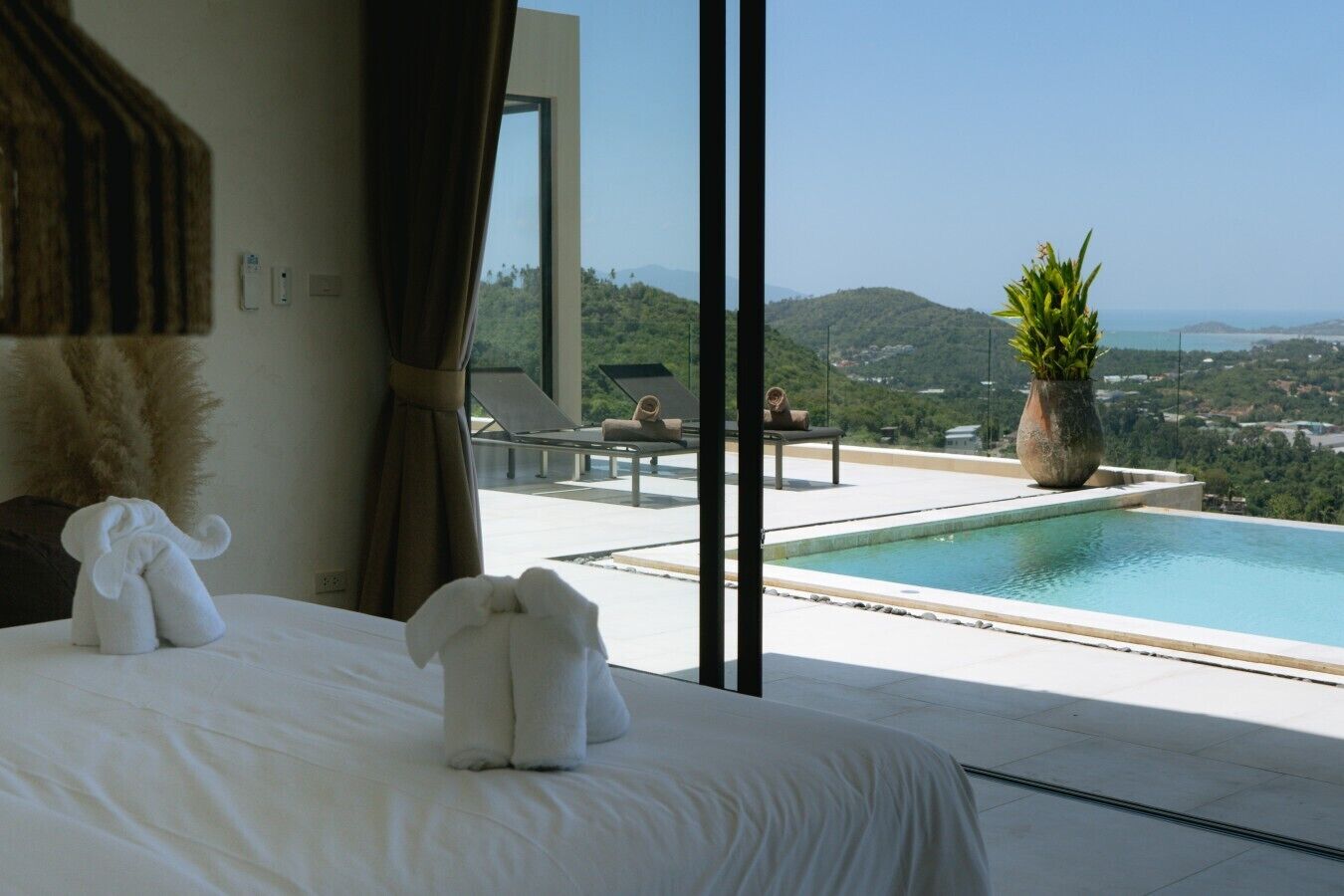 Ein Hotelzimmer mit einem großen Bett, Blick auf einen Pool und eine schöne Landschaft.