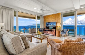 Ein geräumiger Balkon mit Meerblick, eine gemütliche Sitzecke mit Fernseher und Deckenventilator.