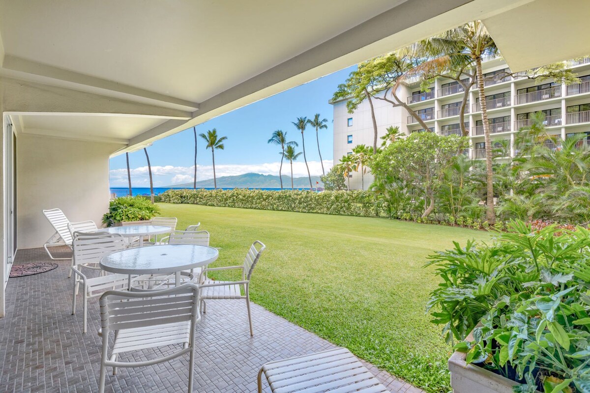 Eine Hotelterrasse mit Sitzgelegenheiten im Freien, Blick auf das Meer und ein Gebäude mit mehreren Balkonen.
