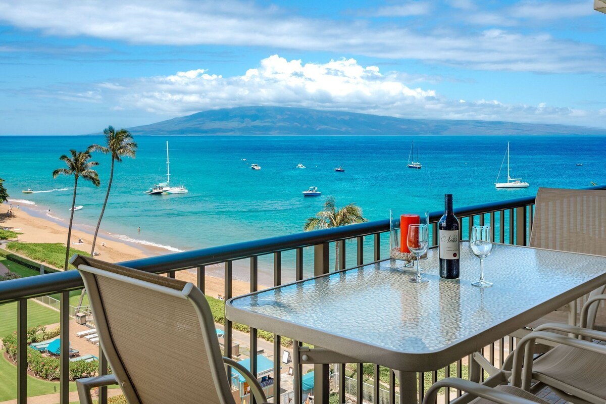 Ein Balkon mit Tisch, Stühlen und Blick auf das Meer mit Booten.