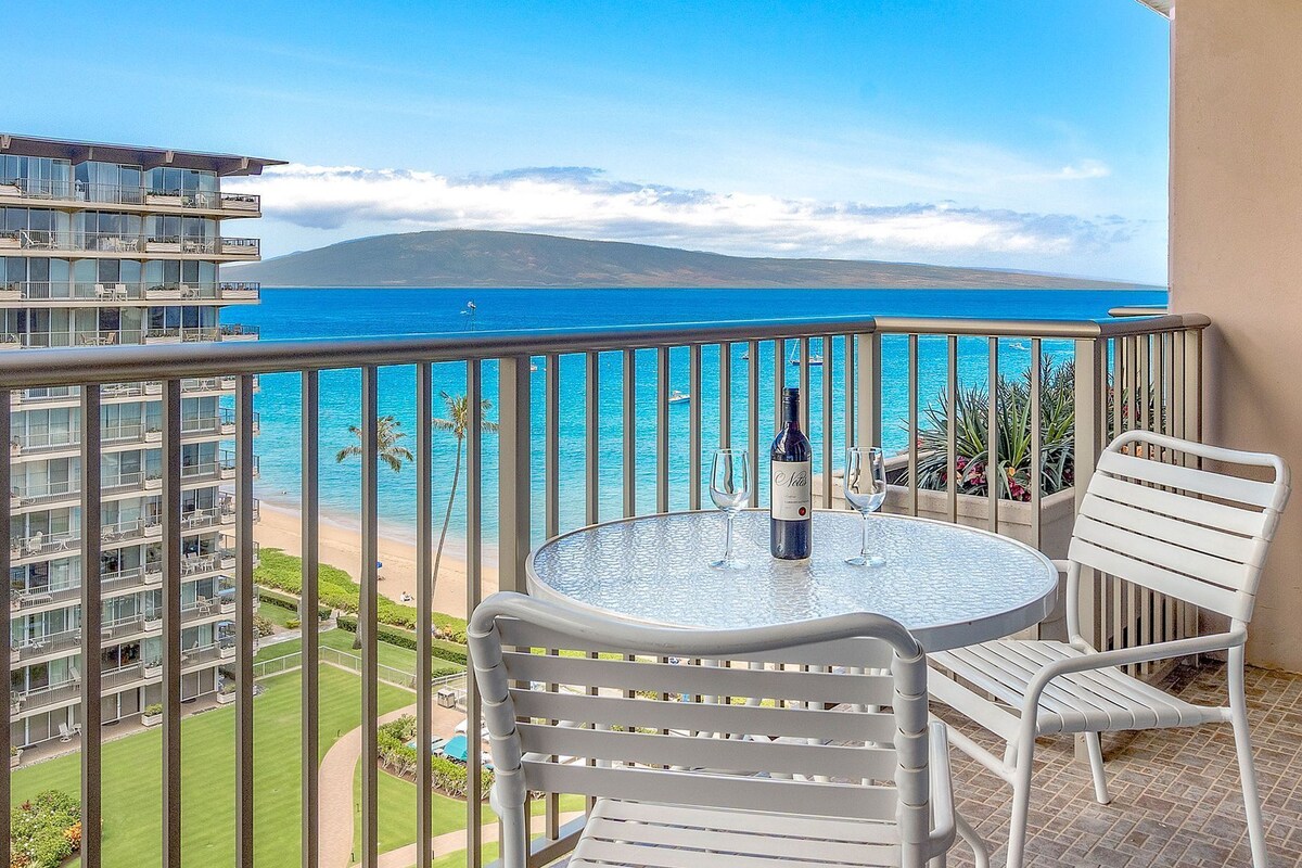 Ein Balkon mit Tisch, zwei Stühlen und einer Weinflasche.
