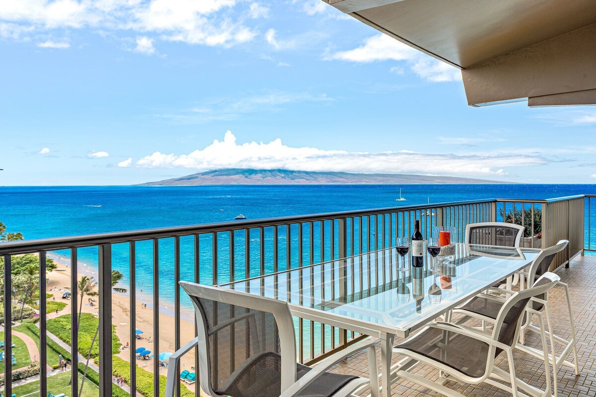 Ein Balkon mit Glastisch und Stühlen mit Blick auf Strand und Meer.