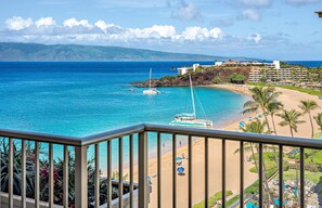 Ein Küstenblick mit Strand, Booten und einem Hotel.
