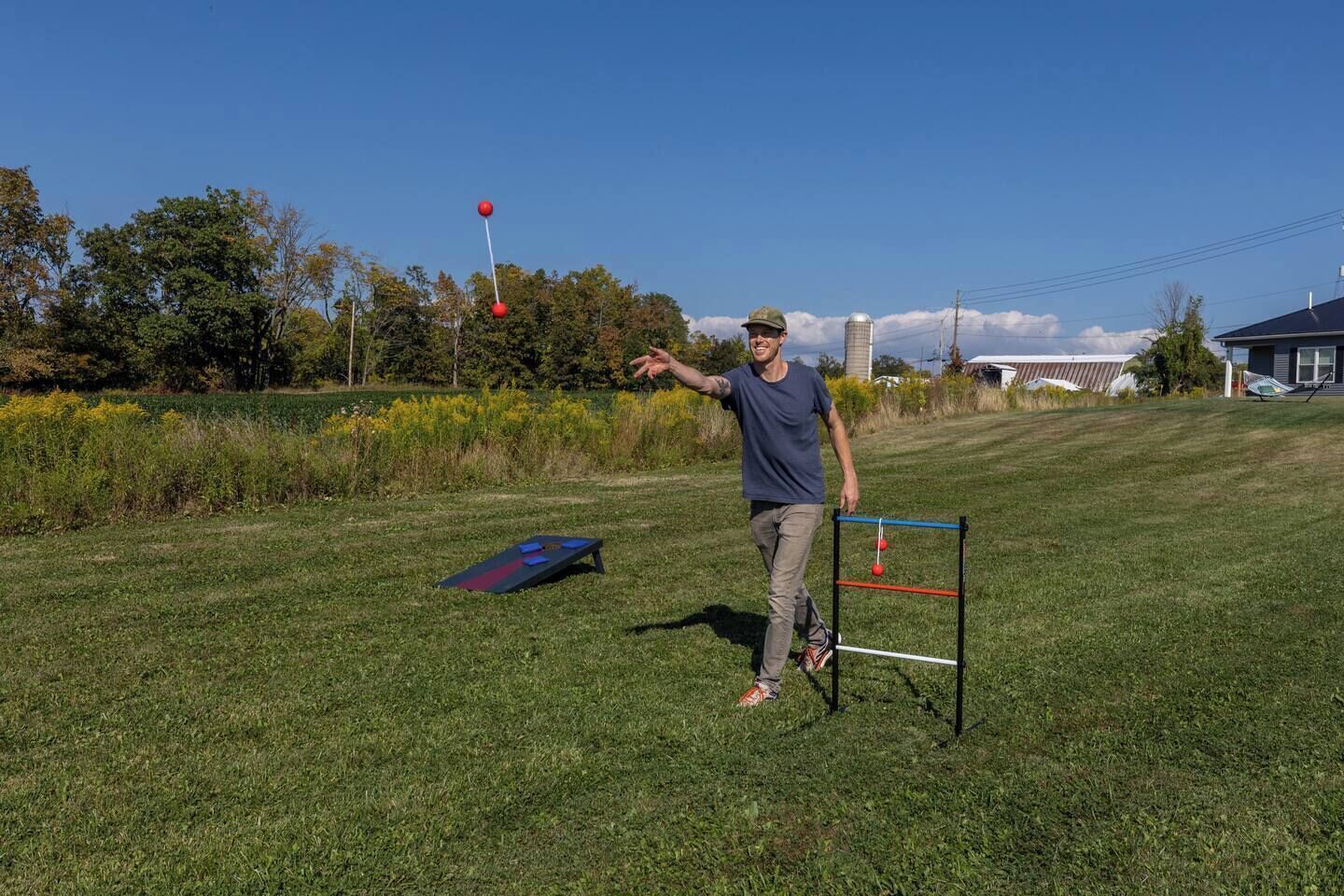 A grassy outdoor area with a person standing next to a red ball on a tee.