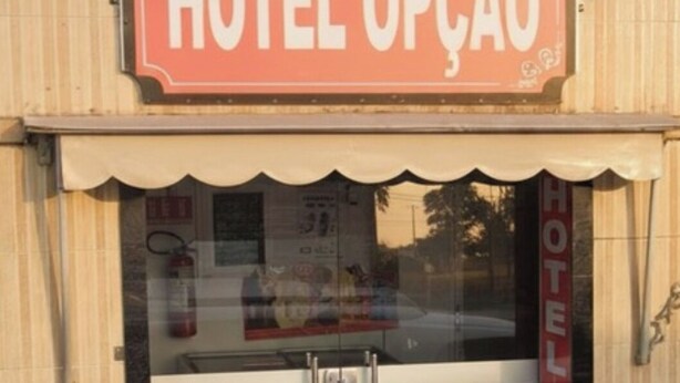 A hotel entrance with a sign reading 'HOTEL OPÇÃO' and a glass door. - Hotel Opção (Manaus)