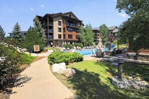 A hotel with a pool area, outdoor seating, and a landscaped garden. - First Tracks at Wildhorse | Gondola + Hot Tubs (Steamboat Springs)