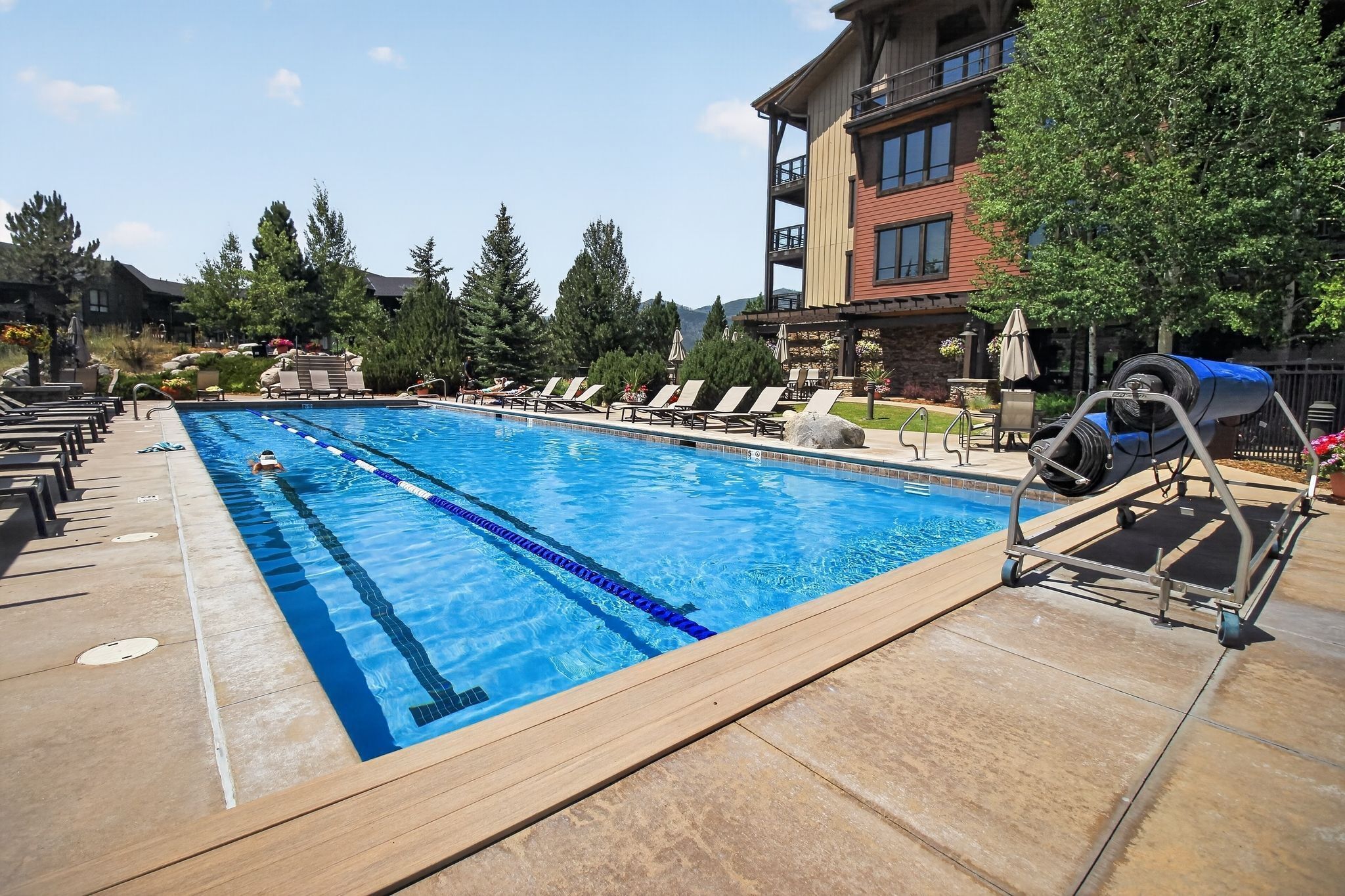 A swimming pool with lounge chairs and a building in the background.