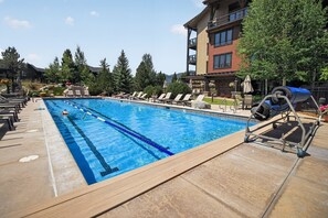 Una piscina con lettini e un edificio sullo sfondo.