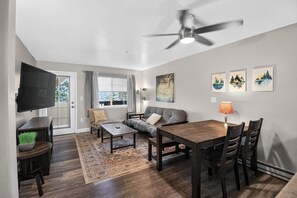 A modern living room with a sofa, coffee table, and dining table. - First Tracks at Wildhorse | Gondola + Hot Tubs (Steamboat Springs)