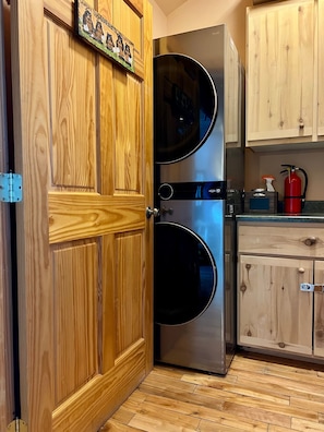 A kitchen with wooden cabinetry, a stainless steel appliance, and a fire extinguisher.