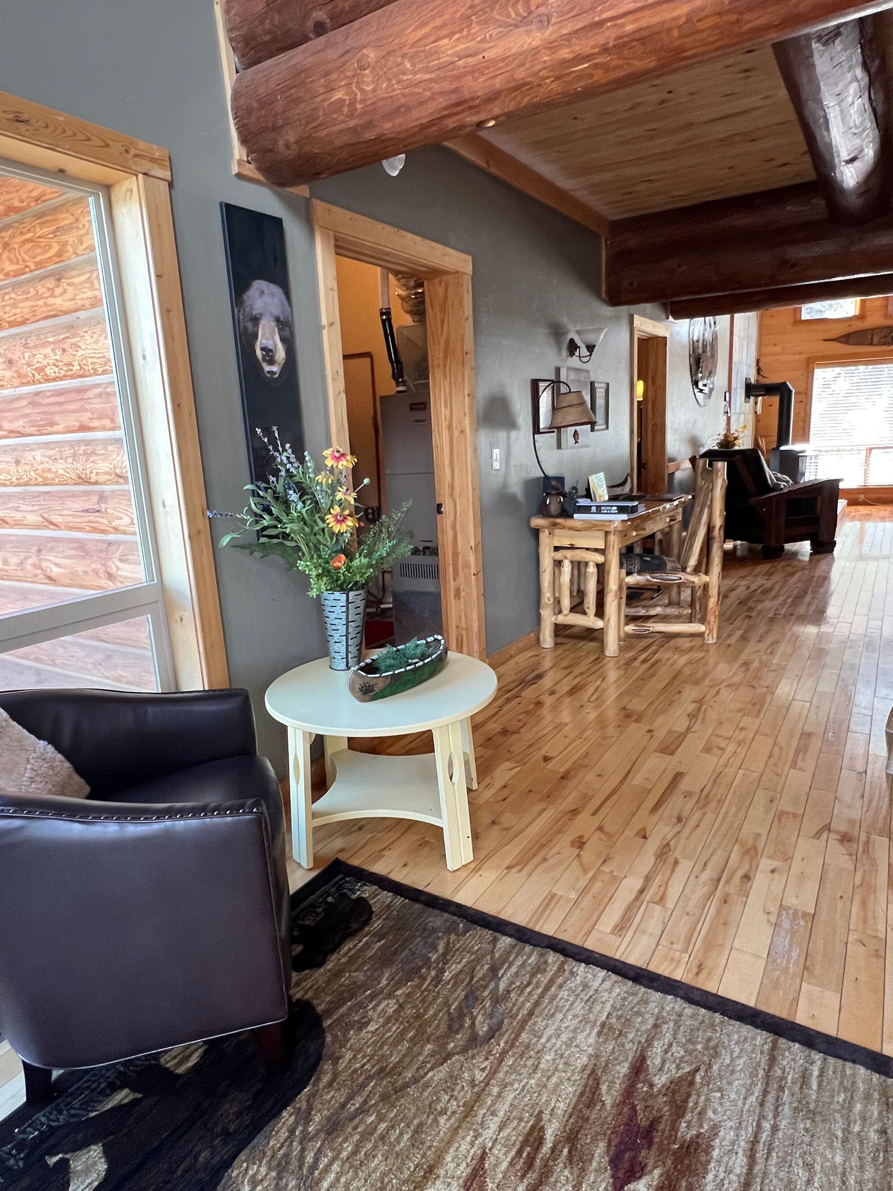 Ein Holzinterieur mit einer Couch, einem kleinen Tisch mit Pflanze und einem Essbereich mit Stühlen.