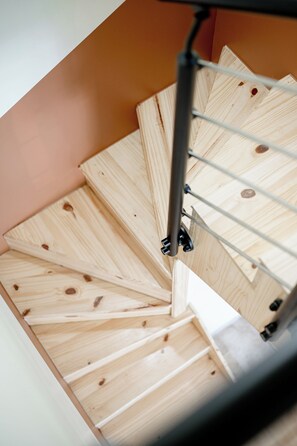 A spiral staircase with wooden steps and metal railings. - Le Chai de Canteloup (Yvrac)