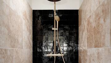 A shower with a handheld showerhead and a handheld shower attachment.