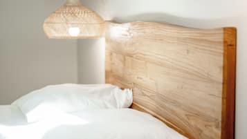A bed with white bedding and a wooden headboard.