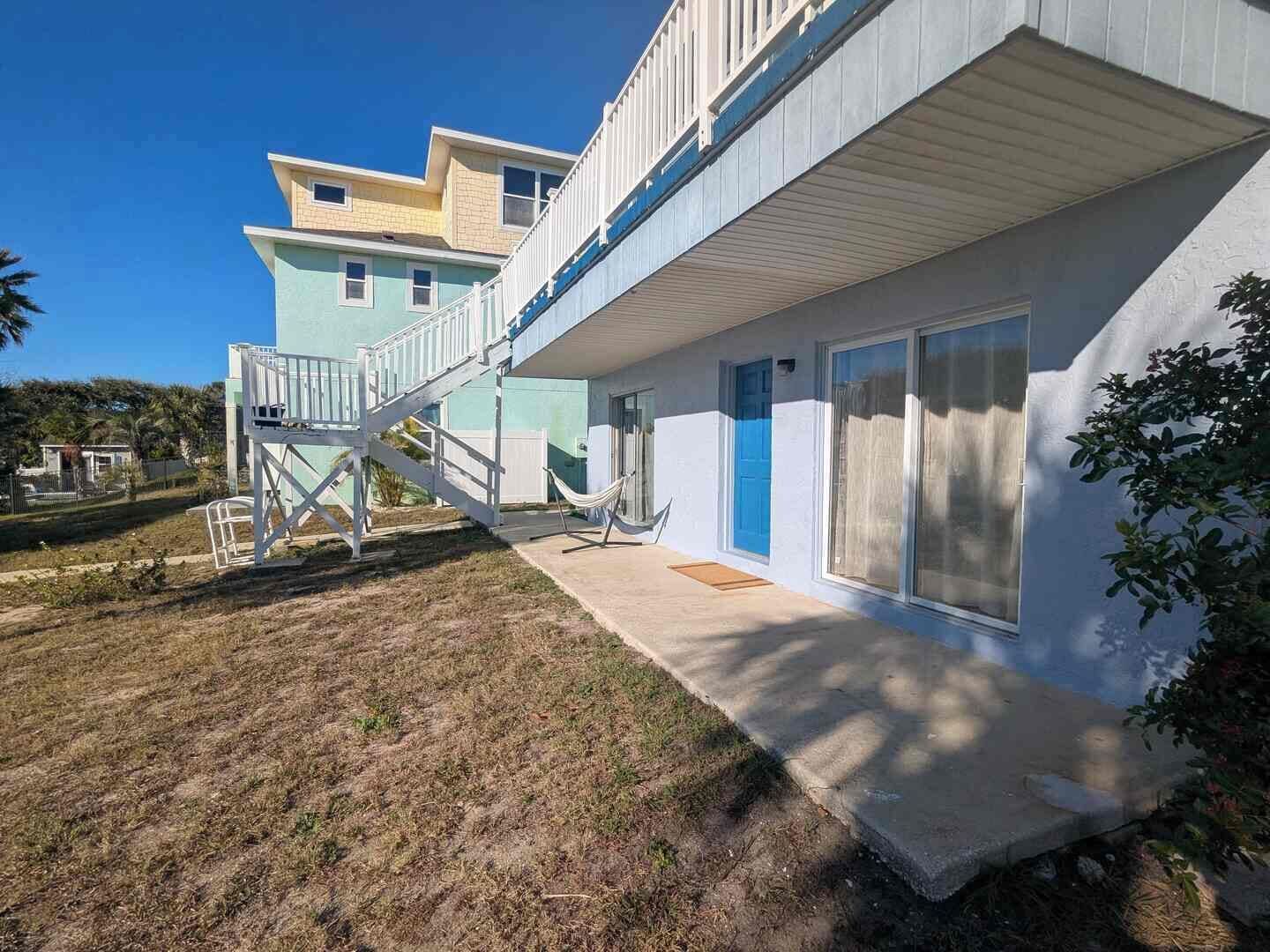 Un bâtiment à deux étages doté d’un espace extérieur couvert et d’un escalier menant à l’étage supérieur.