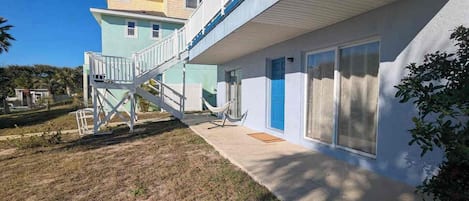 A two-story building with a covered outdoor area and a staircase leading to the upper level.