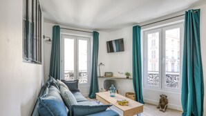 Una sala de estar moderna con un sofá, una mesa de centro y un televisor montado en la pared.