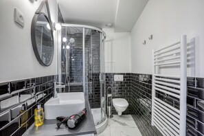 A modern bathroom with a glass-enclosed shower, a white sink, and a toilet. - MATISSIA Monceau (Paris)