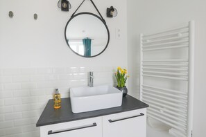 A bathroom with a white sink, black countertop, and a white towel rack. - MATISSIA Monceau (Paris)