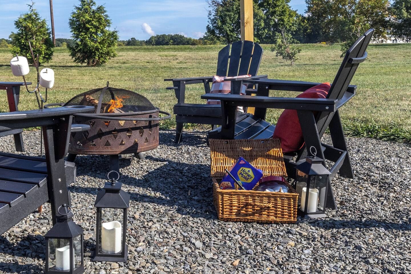 Outdoor seating with a fire pit, a wicker basket with items, and a lantern.