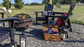 Outdoor seating with a fire pit, a wicker basket with items, and a lantern.