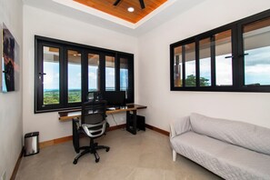 A room with a desk, a chair, a sofa, and large windows with a view. - Villa Serenity, 4-bedroom luxury ocean view with Pool and Trails Near Dominical (Uvita)