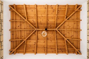 Eine Holzbalkendecke mit einer zentralen Leuchte.
