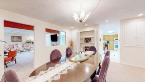 Un comedor moderno con una mesa redonda, sillas y un centro de mesa decorativo.
