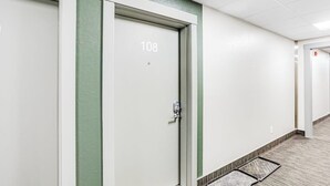 A hallway with doors numbered 108 and 109, a doormat, and a carpeted floor. - Budget-friendly Studio Near Alyeska Lifts (Girdwood)