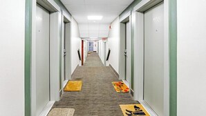 A hotel hallway with doors numbered 100 and 108, carpeted floors, and a carpeted mat at the entrance. - Budget-friendly Studio Near Alyeska Lifts (Girdwood)