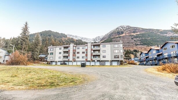 A multi-story residential building with a parking lot in front. - Budget-friendly Studio Near Alyeska Lifts (Girdwood)