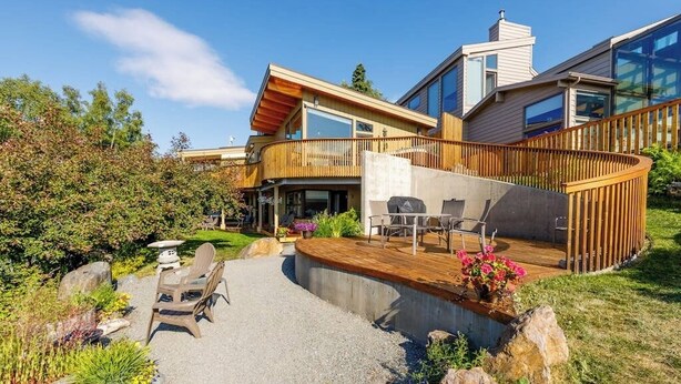 A modern house with a deck, outdoor seating, and a garden. - Award-winning Anchorage Kitchen w/ Cook Inlet Views (Anchorage)