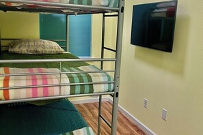 A bunk bed with a television mounted on the wall above it.