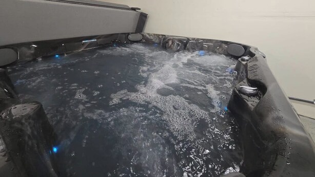 Uma banheira de hidromassagem com água, cercada por uma banheira escura.