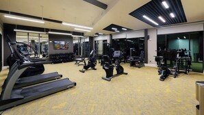 A gym with treadmills, elliptical machines, and weight equipment. - Sleek Haven Suite  | Pool • Gym • Parking | Downtown San Antonio (San Antonio)