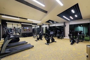 A gym with treadmills, elliptical machines, and weight equipment. - Sleek Haven Suite  | Pool • Gym • Parking | Downtown San Antonio (San Antonio)