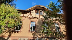 A two-story building with a brick facade, multiple windows, and a gabled roof.
