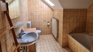 A bathroom with a sink, toilet, and bathtub.