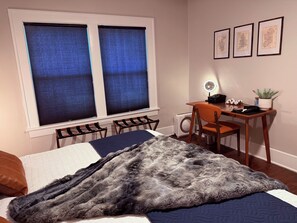 A bedroom with a bed, a desk, and a chair. There are three framed pictures on the wall. - Historic 1914 Texas Tudor: Walk to TTU Campus (Lubbock)