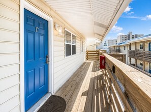 A wooden deck with a blue door, a red mailbox, and a clear sky. - Gulf View 17: Steps to Beach, Walk to The Hangout, Pool, Pet-Friendly (Gulf Shores)