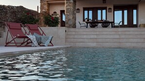 A pool area with lounge chairs and a dining setup. - Las Pazuelas, the perfect rural getaway (Parrillas)