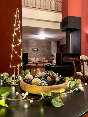 A cozy living room with a fireplace, a wooden coffee table with decorative items, and a staircase leading to an upper level.