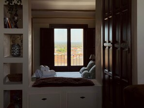 A room with a bed, a window with shutters, a view of the city, and a door. - Las Pazuelas, the perfect rural getaway (Parrillas)