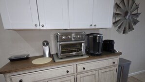 A kitchen with a built-in oven, a coffee maker, and a decorative windmill on the wall. - Wonderful condo with cool AC, pool in charming Ship Bottom.Very spacious studio. (Ship Bottom)